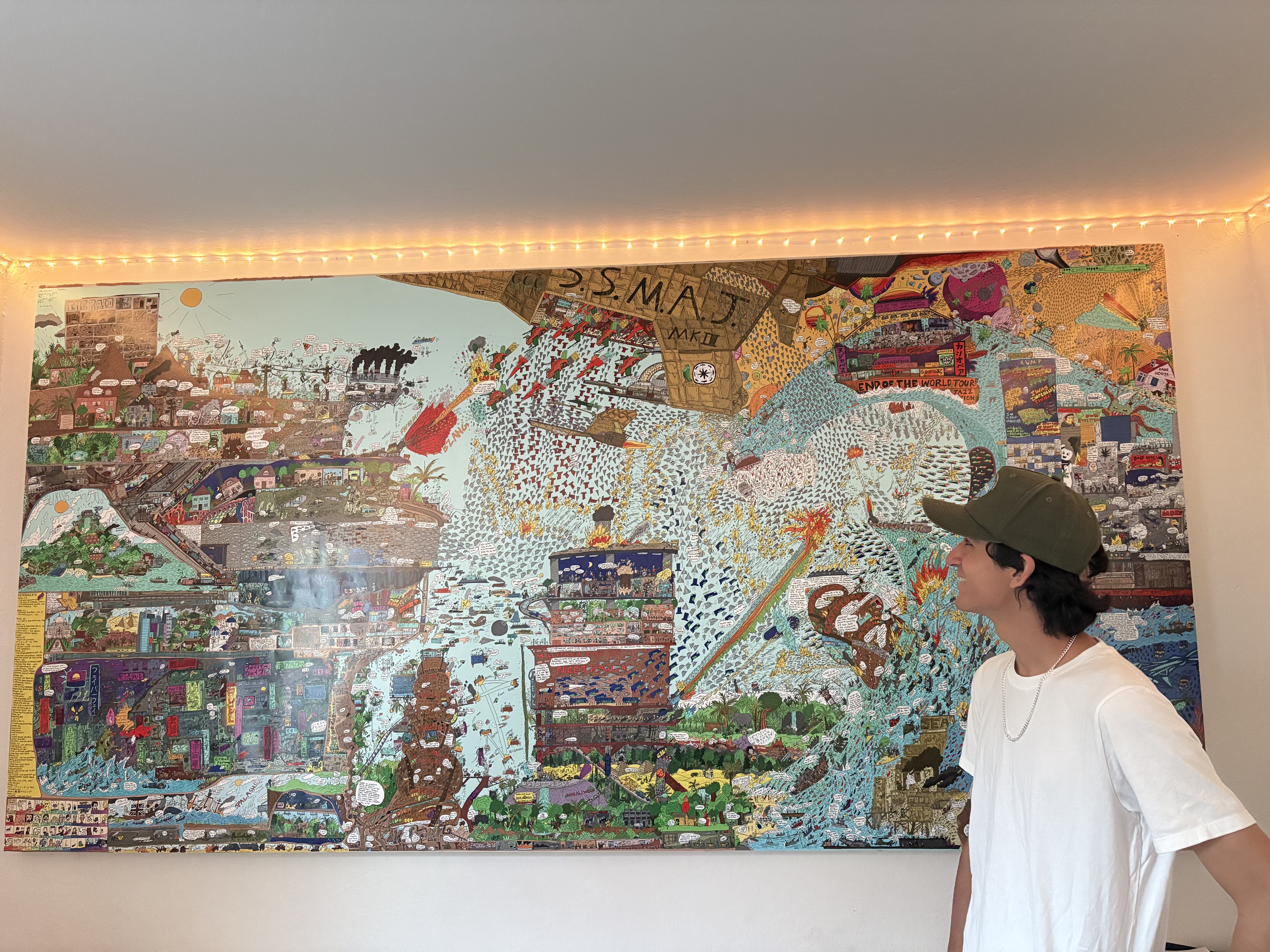 Zion D. C. standing in front of his D.S.M.A.J. mural